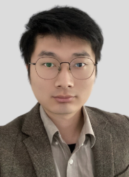 Guanzhou Wei Headshot A man wearing a brown suit looks into the camera