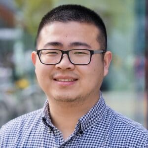 Head-and-shoulders portrait of a person in a checkered shirt.