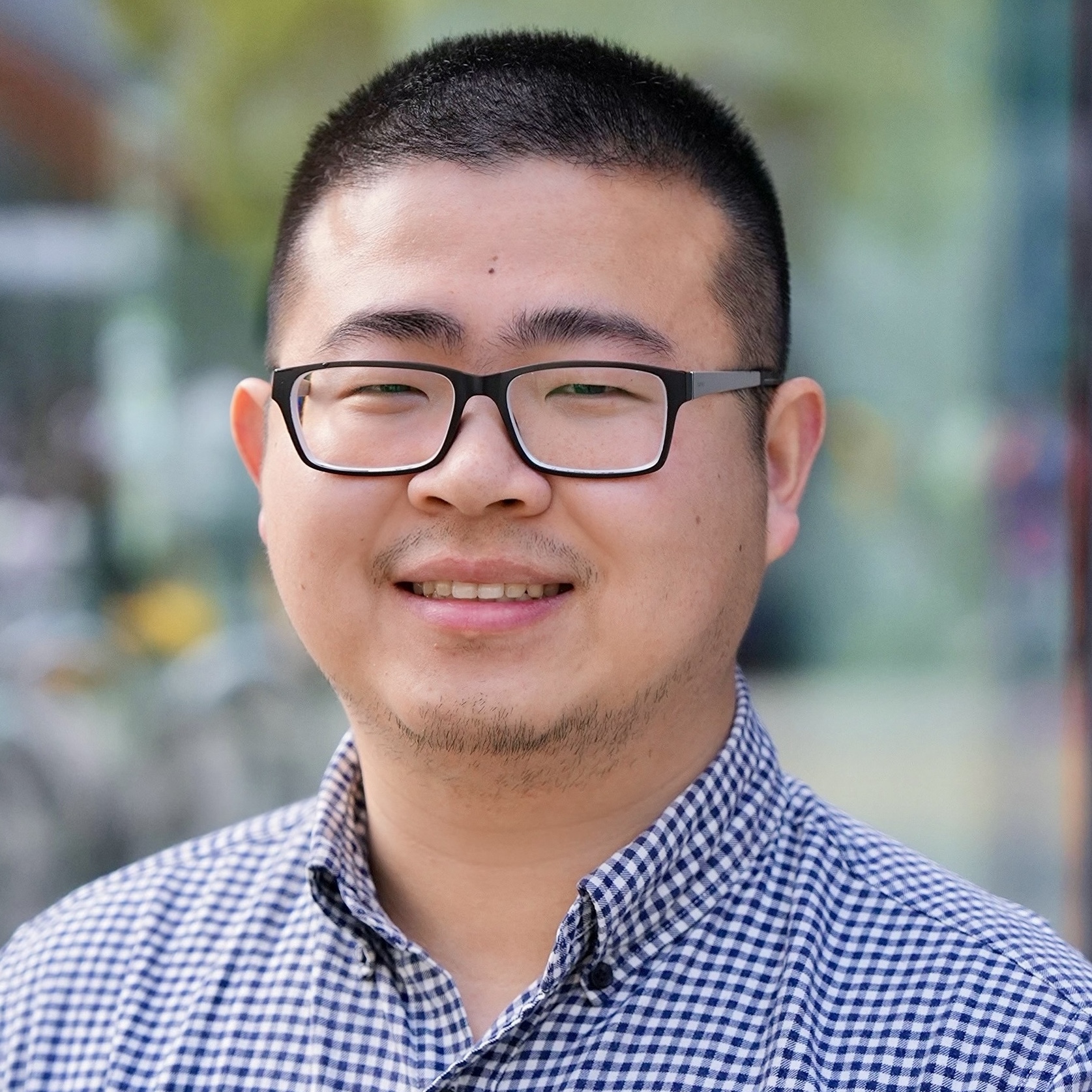Head-and-shoulders portrait of a person in a checkered shirt.