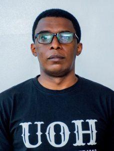 Man looking at camera with a stoic expression on his face.