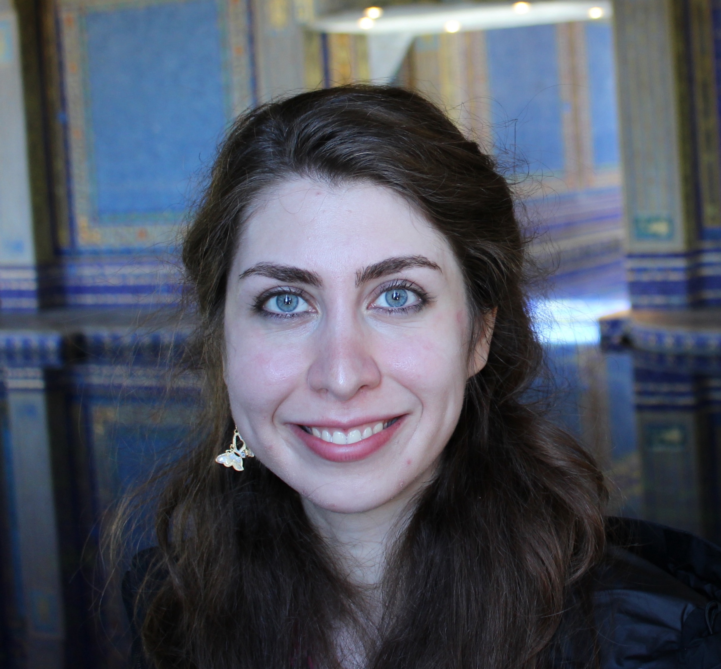 Studio headshot of a woman in front of a stone or architectural background