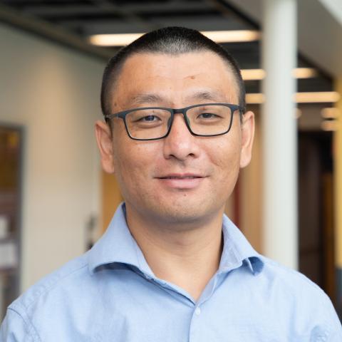 Indoor portrait of a man in a light blue shirt.
