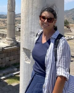 Outdoor portrait of a person wearing a backpack, standing near stone columns
