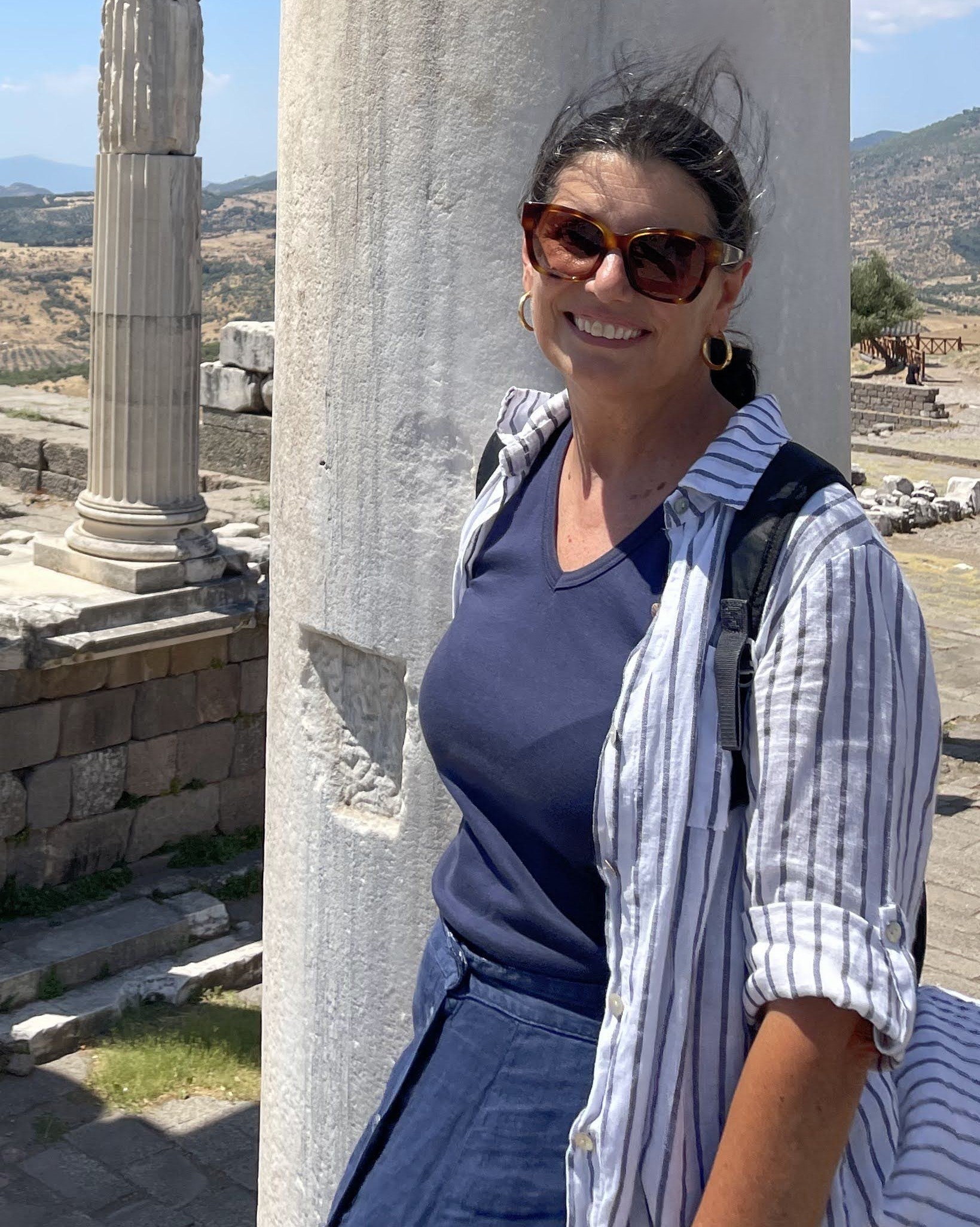 Outdoor portrait of a person wearing a backpack, standing near stone columns