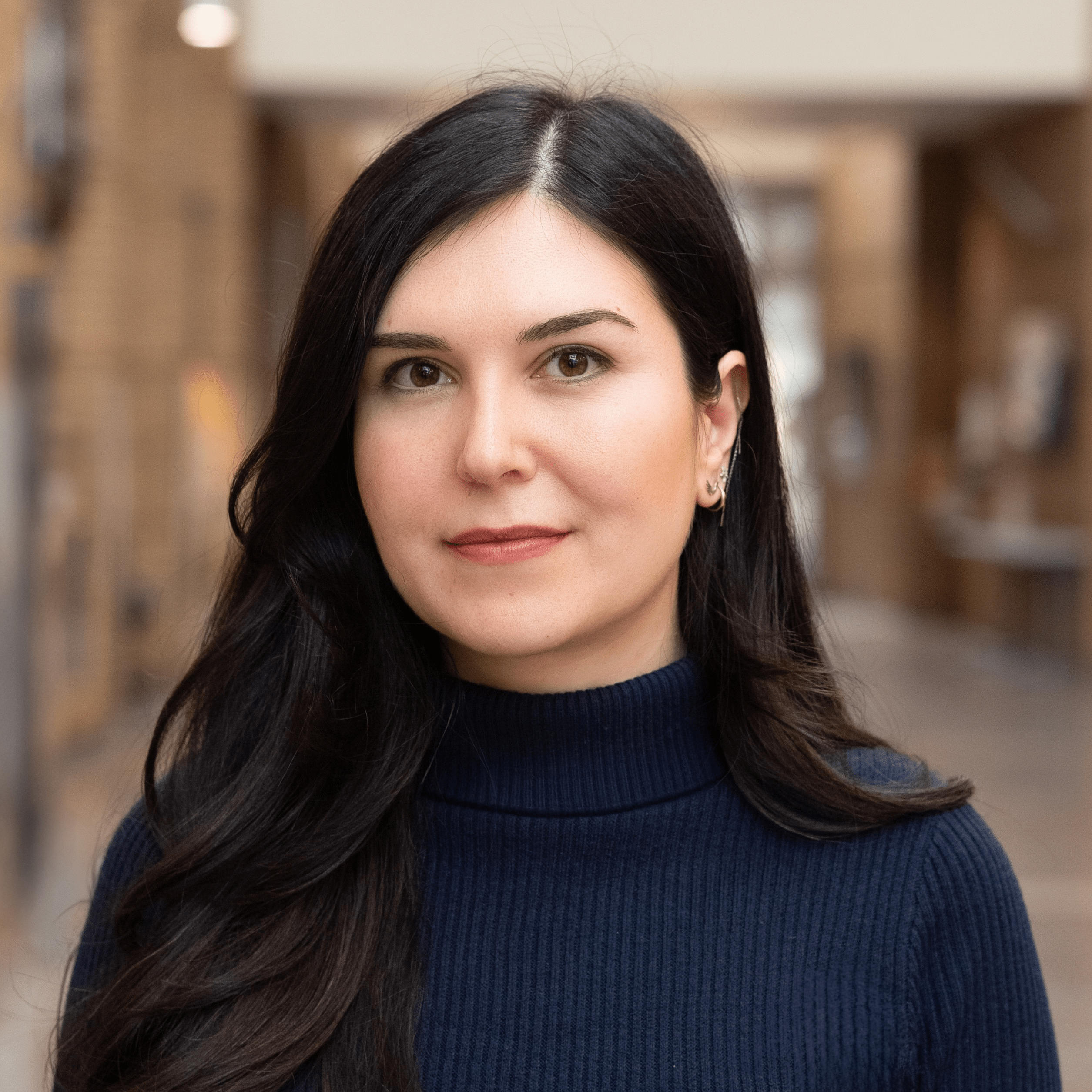 Indoor portrait of a woman in a navy sweater.