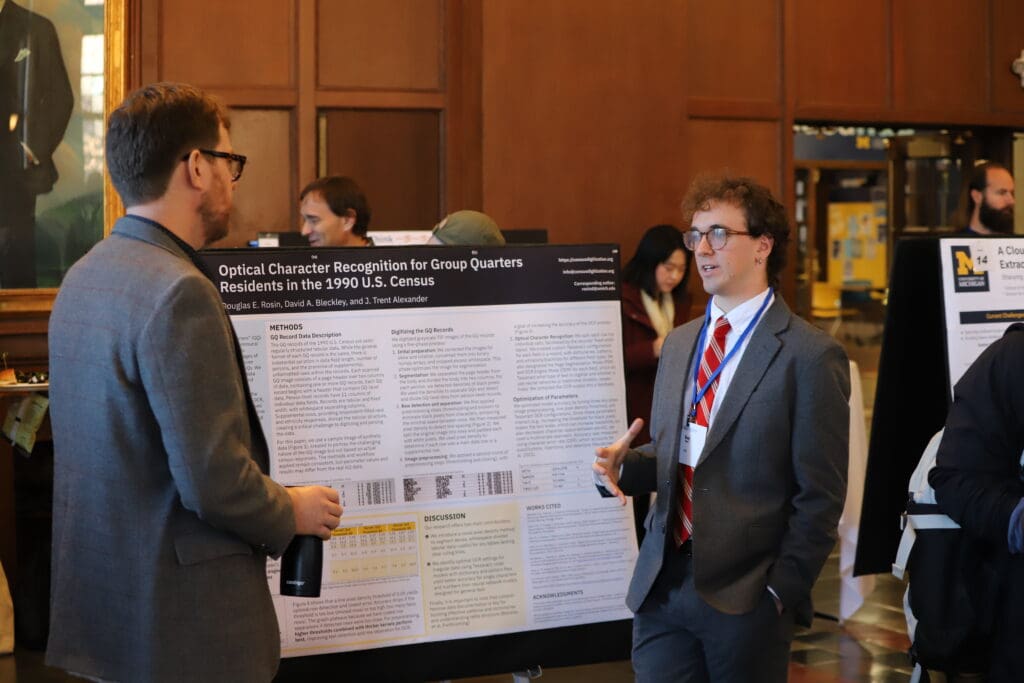A person standing in front of their poster presenting to an onlooker