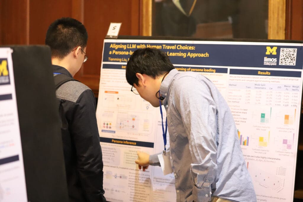 A person standing in front of their poster presenting to an onlooker