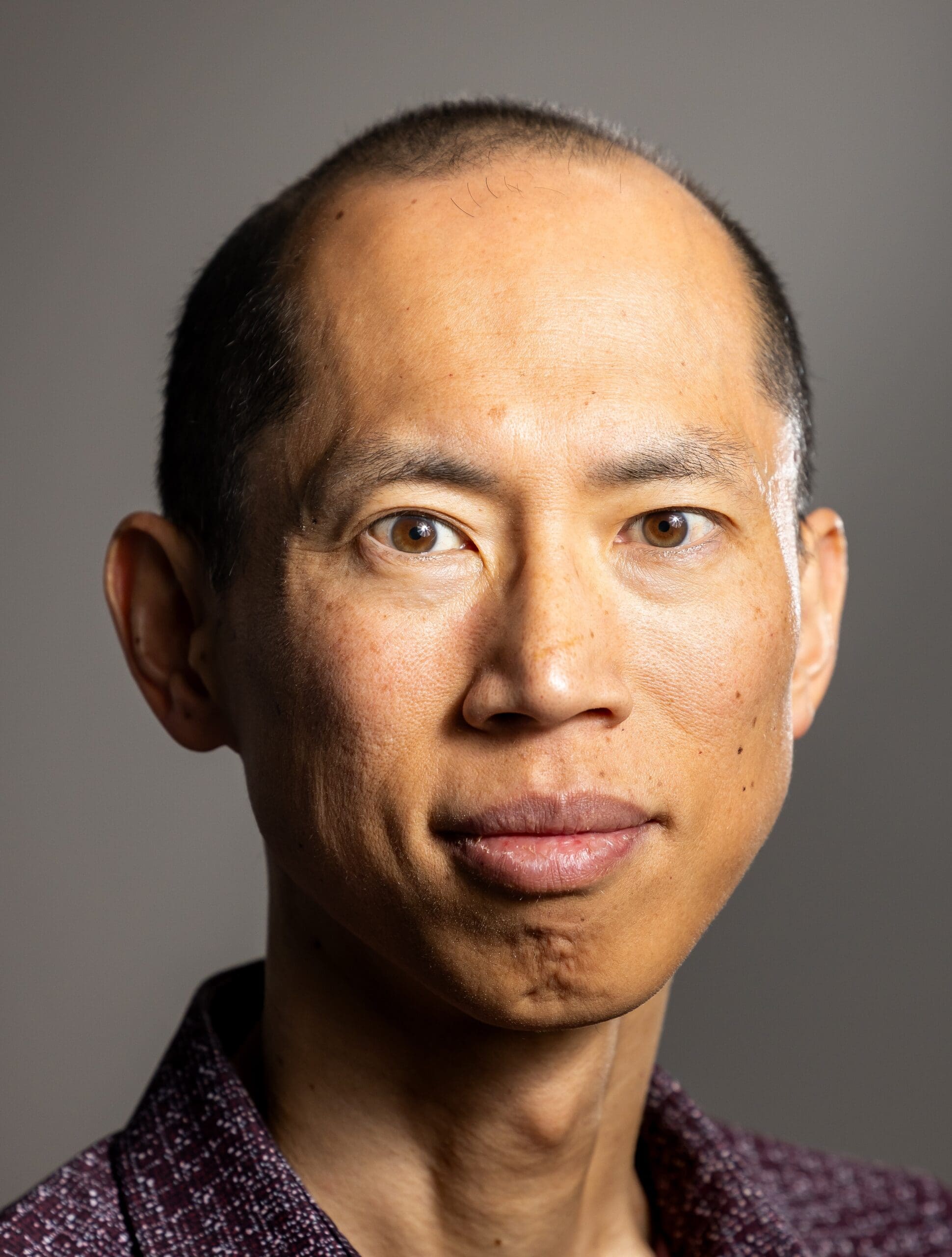 Man looking into the camera with a half smile.