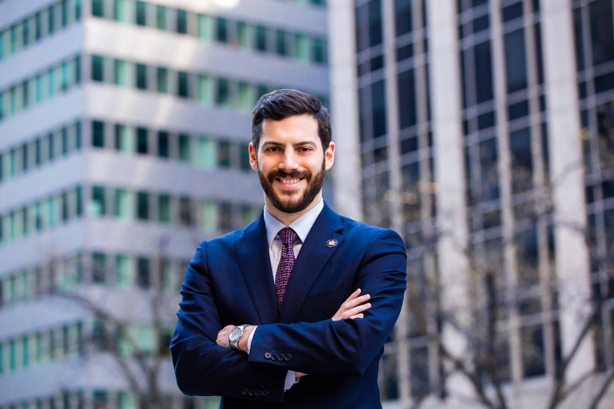 Photo of Alex Bores in a navy suit crossing his arms